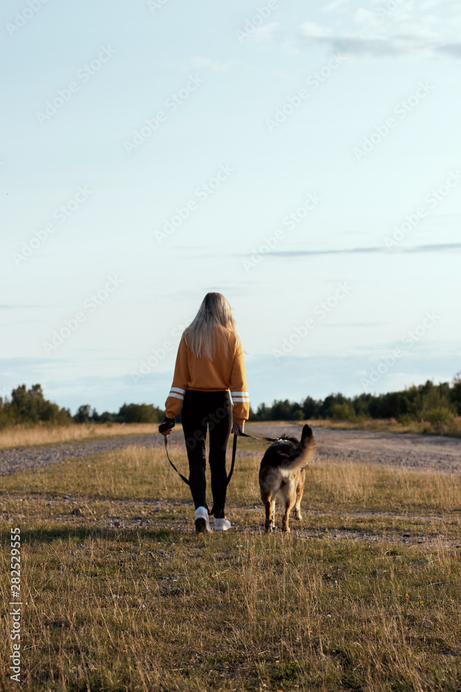 young girl walking with dog, rear view
