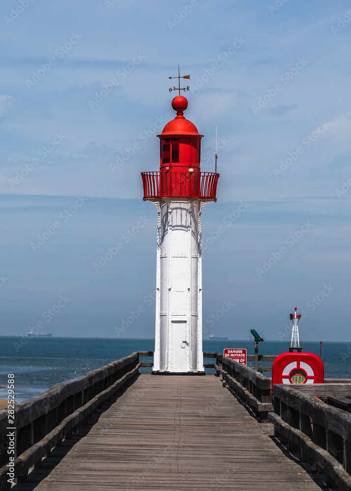 Red lighthouse in Trouville, resort in Normandy, France. Vertical landscape.