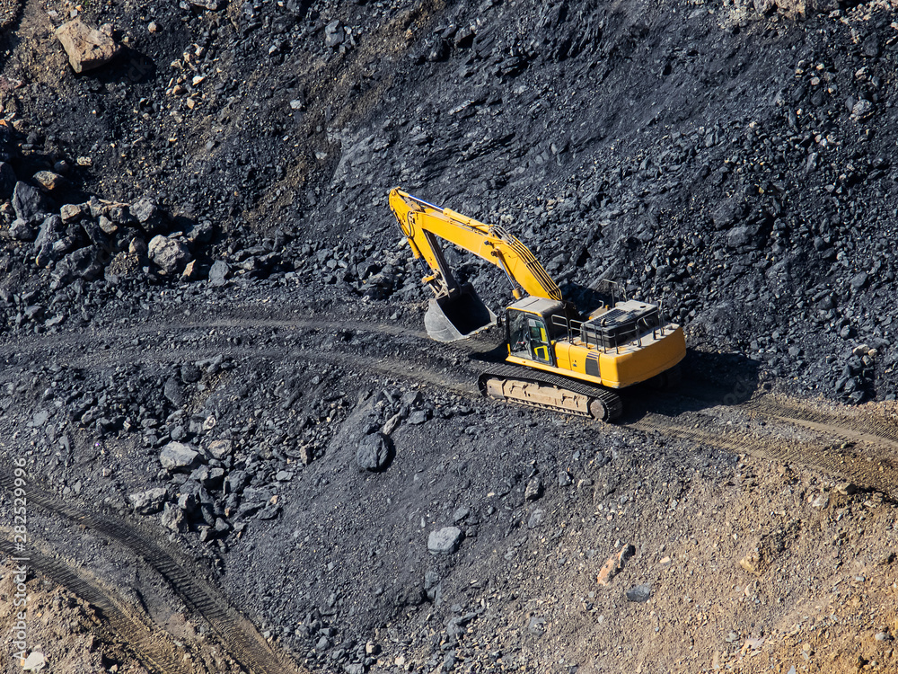 Excavator loading bucket on mining site stock photo Excavator loading bucket on mining site stock photo