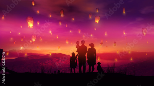 Family with children watching at flying Chinese lanterns at sunset