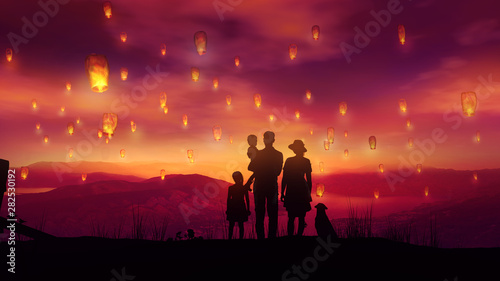 Family with two children and a dog among flying Chinese lanterns at sunset