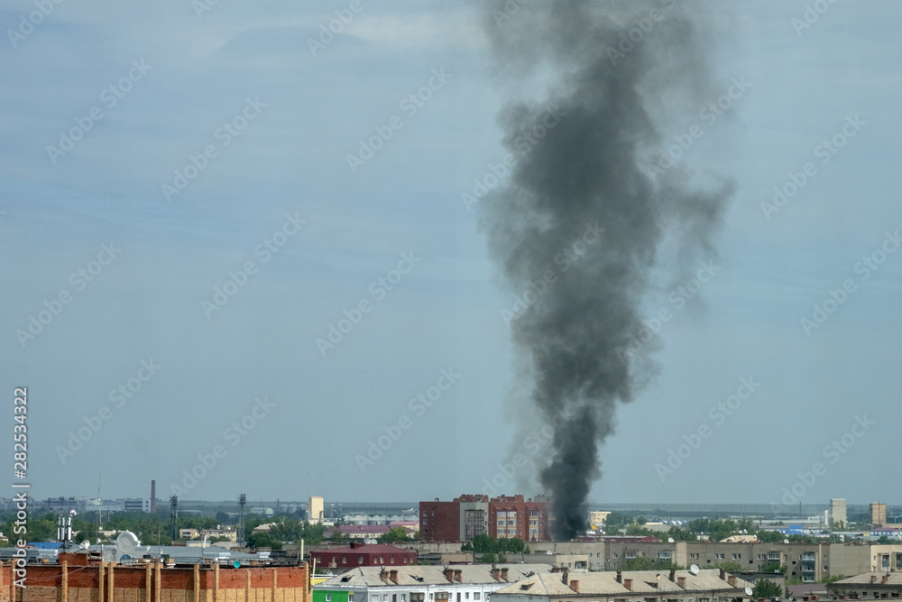 Aerial view on city fire. Plume of smoke above city. Air pollution over homes.