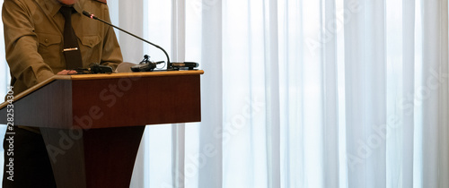 Fotografie Abstract man in a green shirt stands on the podium in front of a microphone