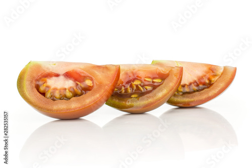 Group of three slices of fresh greenish red tomato isolated on white background