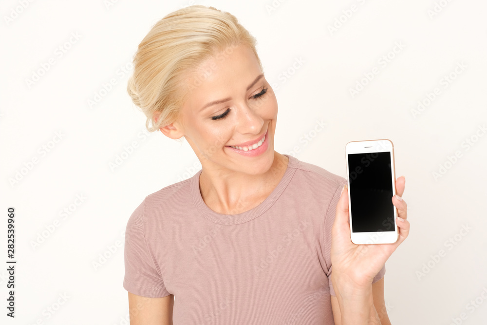 Smiling woman is holding in the hand a mobile phone. Smiling woman is holding in the hand a mobile phone.