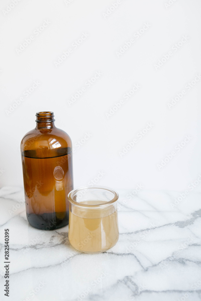 Amber Glass and Cup of Kombucha, Healthy Probiotic Drink, White and Marble Background, Copy Space Amber Glass and Cup of Kombucha, Healthy Probiotic Drink, White and Marble Background, Copy Space
