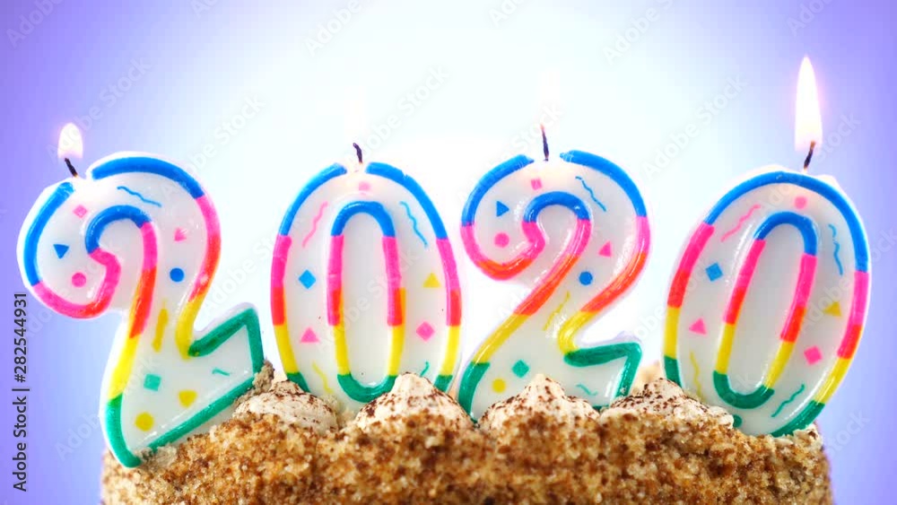 Birthday cake with a burning birthday candle. Number 2020. Background changes color Birthday cake with a burning birthday candle. Number 2020. Background changes color