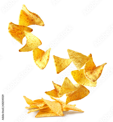 Flying delicious Mexican nachos chips on white background photo