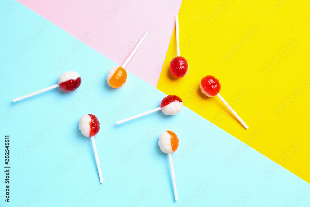 Flat lay composition with delicious lollipop candies on color background Flat lay composition with delicious lollipop candies on color background