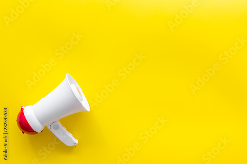 Attract attention with megaphone on yellow background top view copyspace