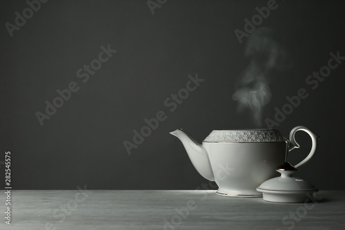 Ceramic teapot on table against grey background. Space for text