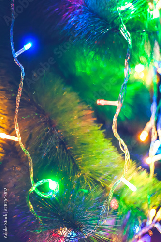 Close-up view of Christmas tree decorated with garland lights