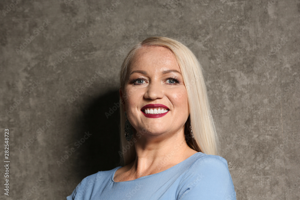Portrait of beautiful mature woman on grey background Portrait of beautiful mature woman on grey background