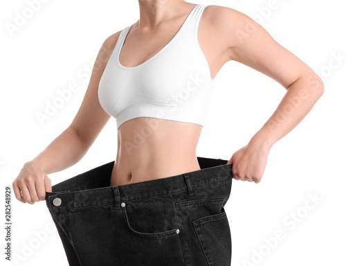 Young slim woman wearing oversized jeans on white background, closeup