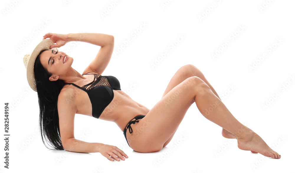 Beautiful young woman in black bikini with hat on white background