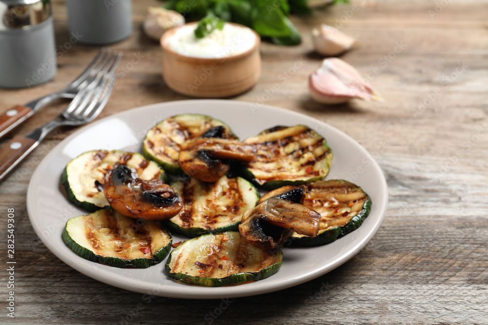 Grilled zucchini slices served on wooden table
