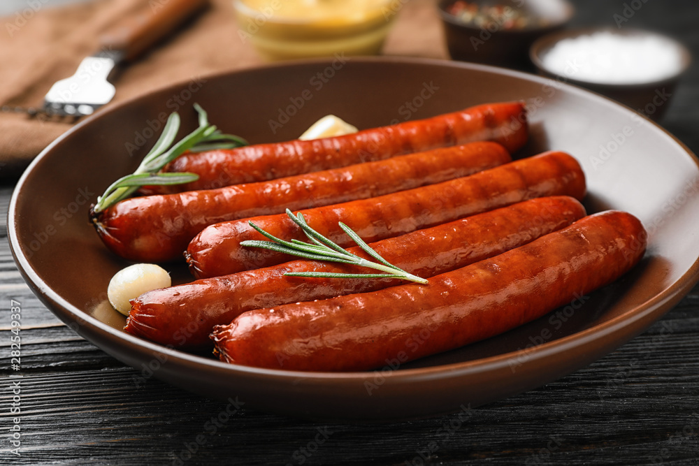 Delicious grilled sausages in bowl on dark wooden table. Barbecue food Delicious grilled sausages in bowl on dark wooden table. Barbecue food