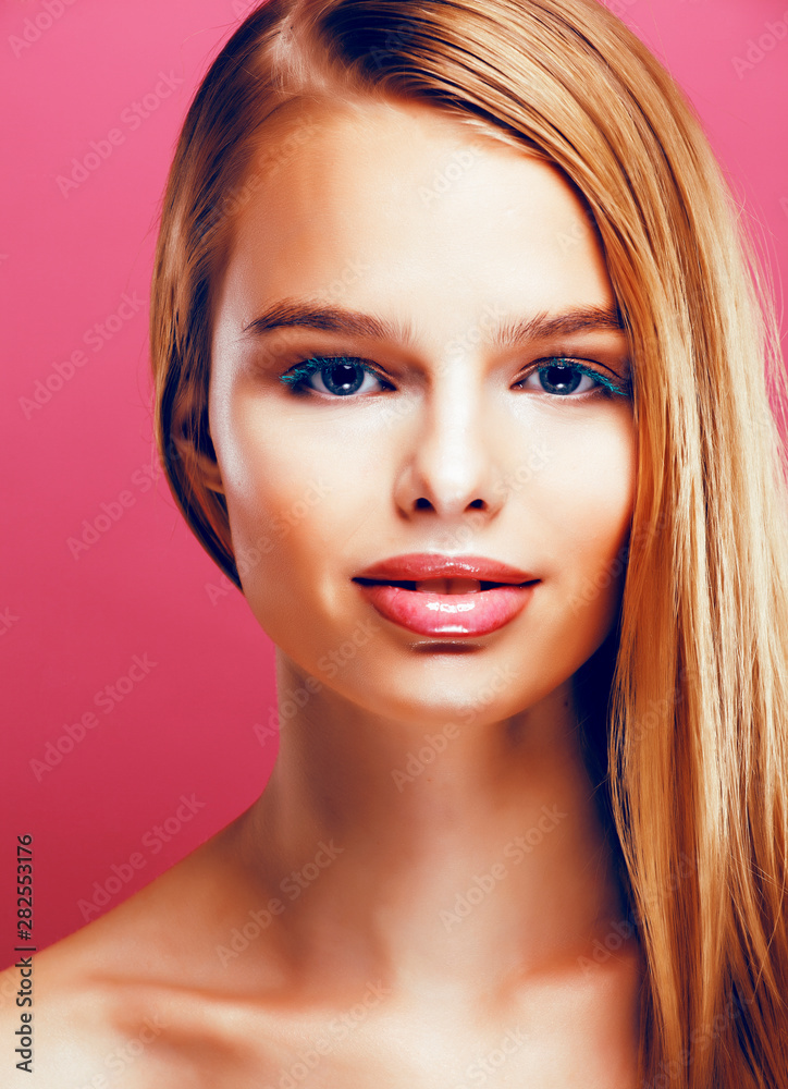 Fototapeta premium young pretty blonde real woman with hairstyle close up and makeup on pink background smiling, stylish fashion look like baby doll