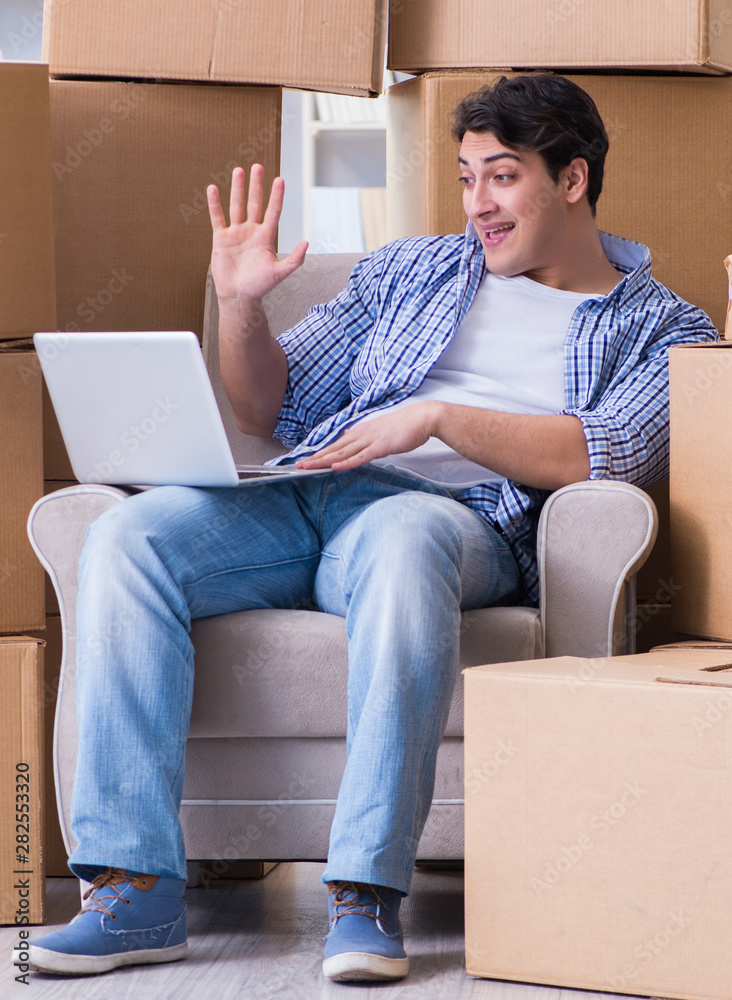 Young man moving in to new house with boxes