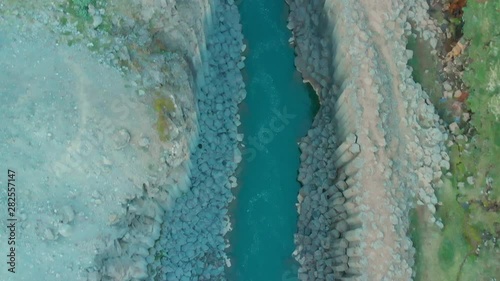 Aerial top view over Stuðlagil Canyon, East Iceland. Impressive landscape with Basalts Colums in  Glacier Valley, crystal clear water of Glacial River. daylight and tourists in The Valley Jökuldalur. photo