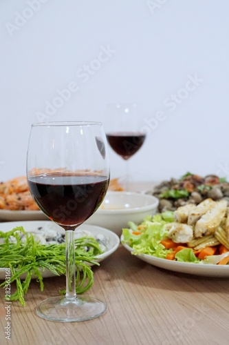 Selective focus, Glass of wine red on blurred food on the table as a background, set of dinner, Vertical