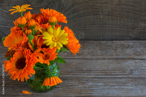 bouquet of calendula on an old wooden background with a copy of space