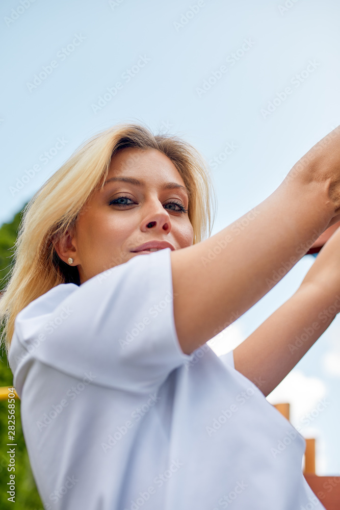 Beautiful young woman smiling at camera in a park outdoors. Outdoor recreation, happy life. Beautiful young woman smiling at camera in a park outdoors. Outdoor recreation, happy life.