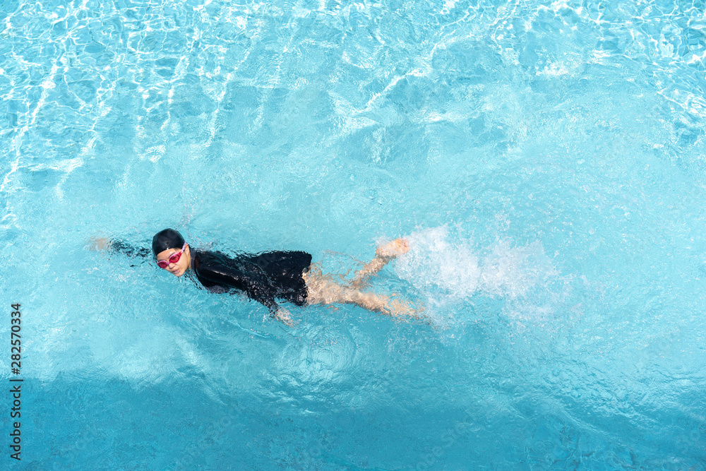 Asian girl swimming in blue pool