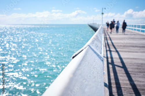 Uranagan Pier Hervey Bay with blue water and blue sky with people walking along it photo