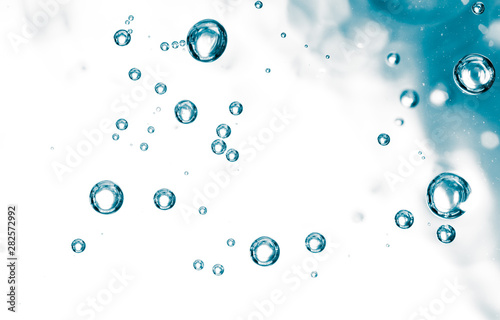Bubbles of air on the smooth surface of blue water as an abstract background