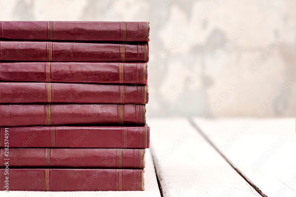 Stack of old ancient shabby books on a white wooden background. Stack of old ancient shabby books on a white wooden background.