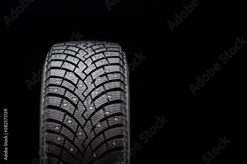 New winter studded tire, safety and premium quality. black background, close-up