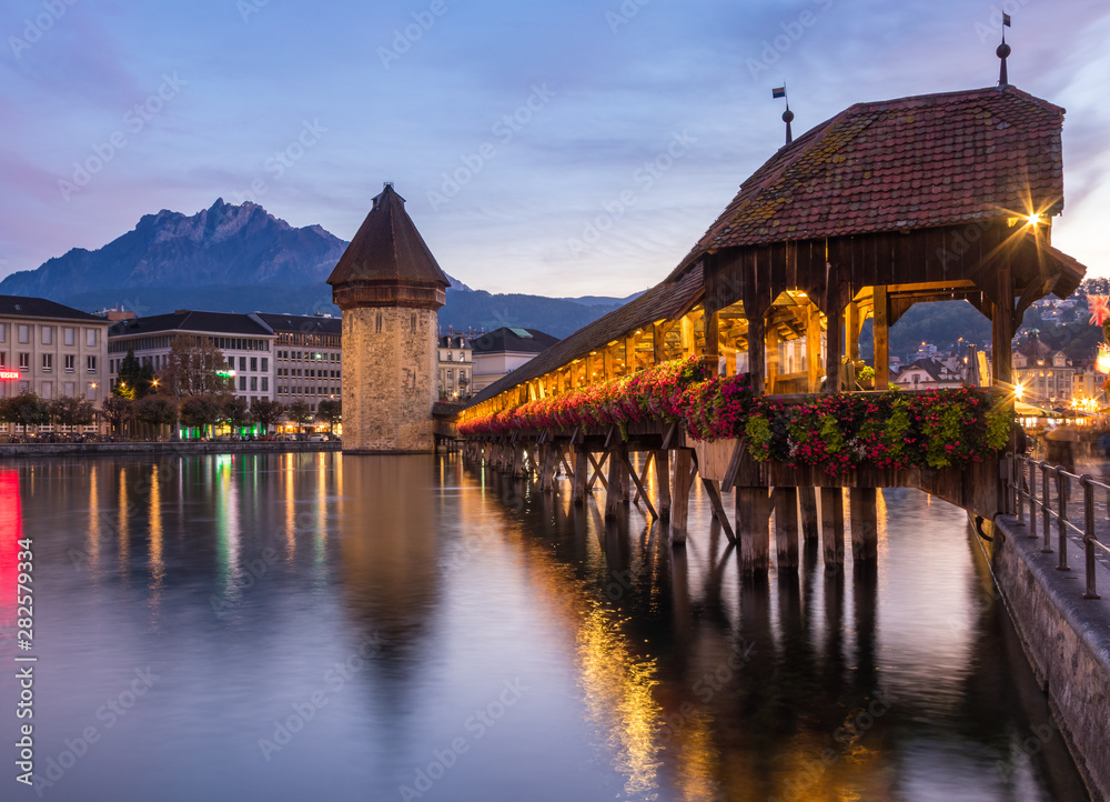 Old wooden architecture called Chapel Bridge in Luzern or Lucerne, Switzerland during sunset and twilight