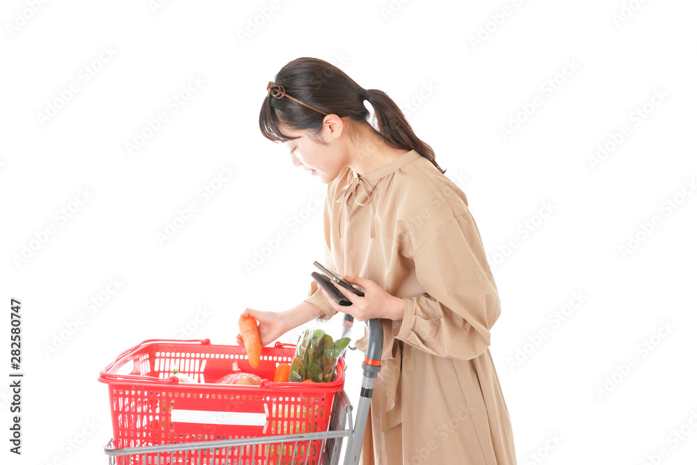 スーパーで食品の原産地を調べる若い女性 スーパーで食品の原産地を調べる若い女性