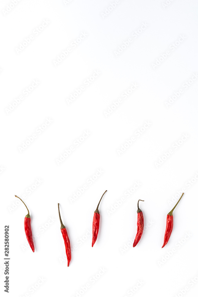 Chilli peppers on white table with copyspace. Abstract background