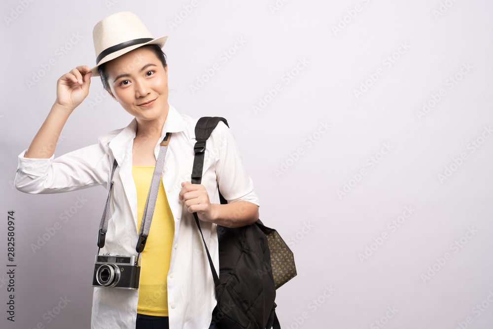 Happy woman holding camera over background and looking at camera