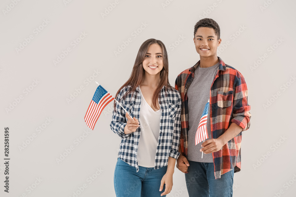 Young people with USA flags on light background