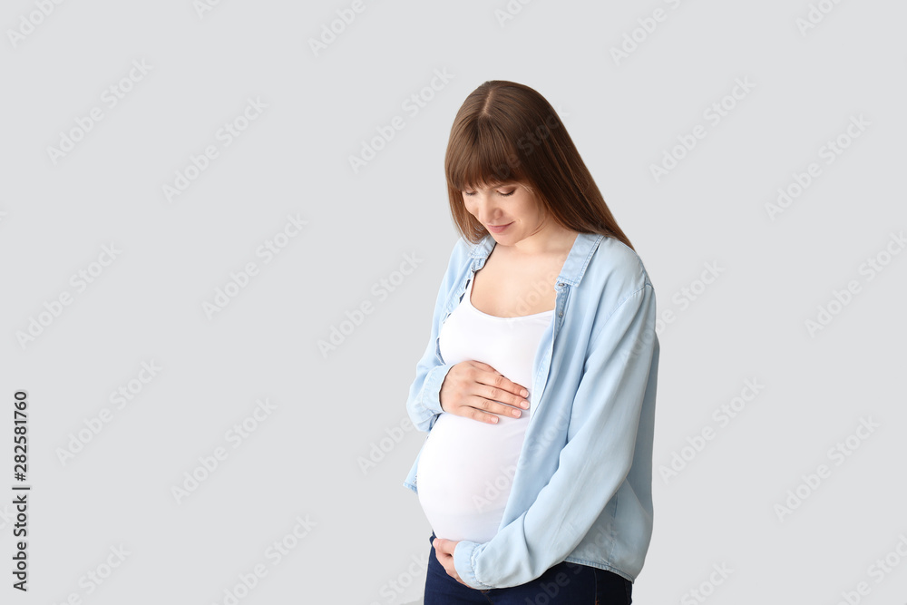 Young pregnant woman on light background Young pregnant woman on light background