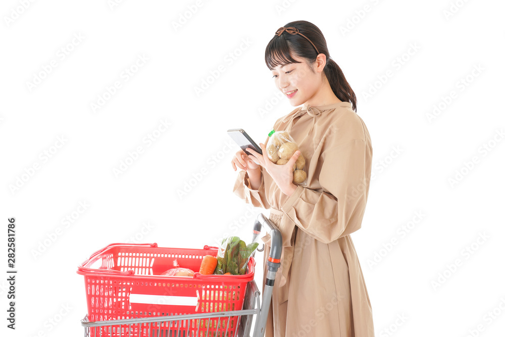スーパーで食品の原産地を調べる若い女性 スーパーで食品の原産地を調べる若い女性