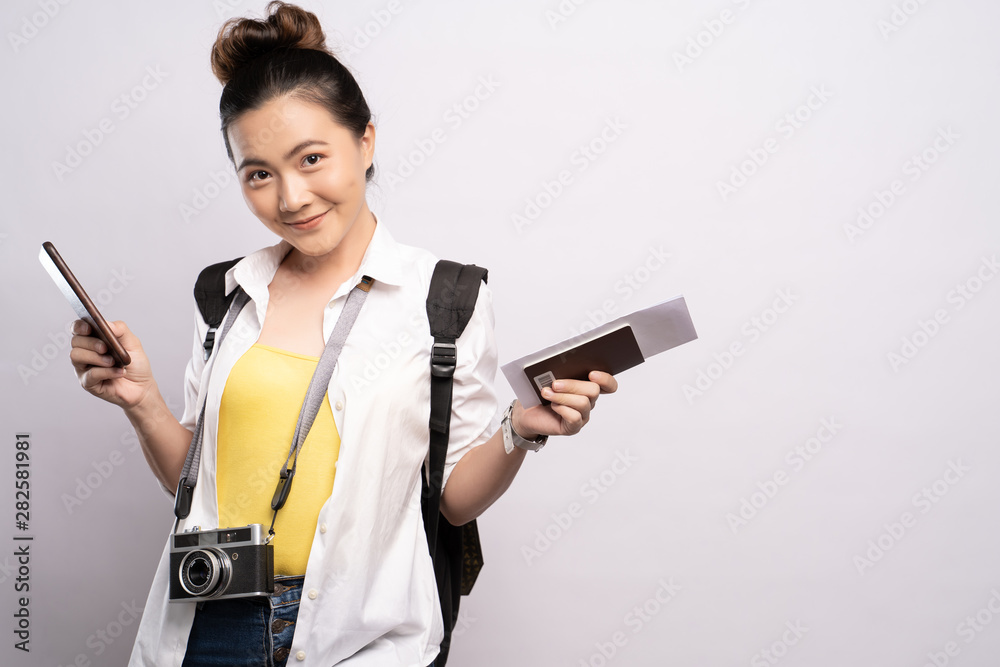 Naklejka Happy woman holding smartphone and travel ticket isolated over white background