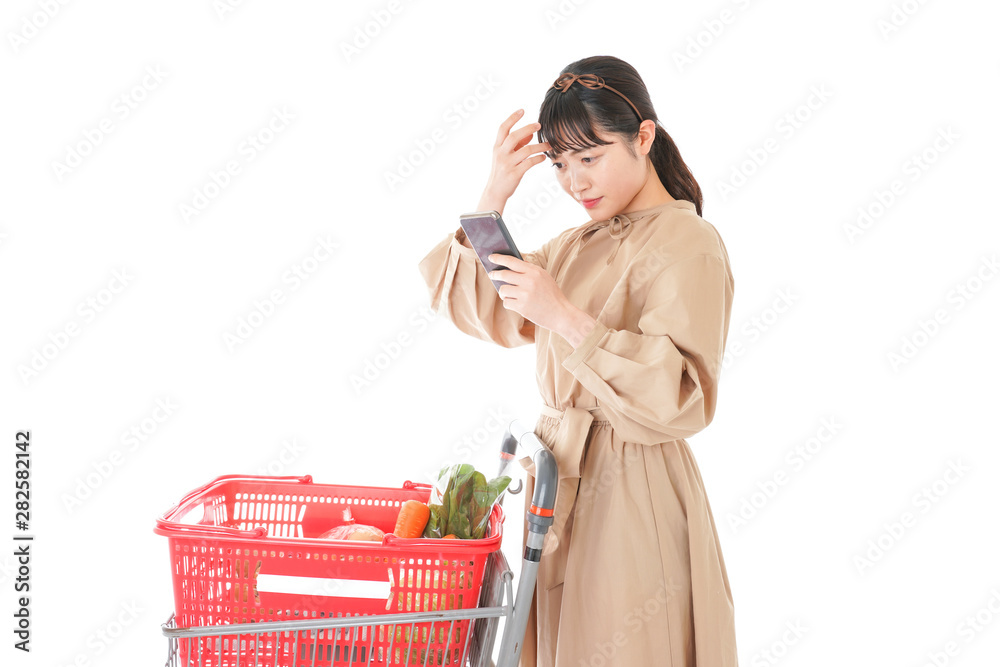 スーパーで食品の原産地を調べる若い女性 スーパーで食品の原産地を調べる若い女性