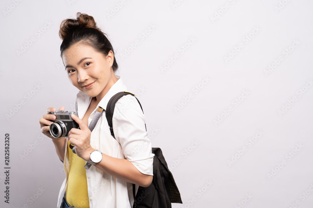 Happy woman holding camera over background and looking at camera Happy woman holding camera over background and looking at camera