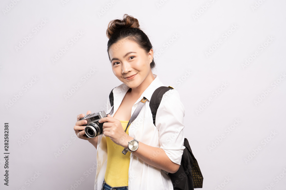Happy woman holding camera over background and looking at camera Happy woman holding camera over background and looking at camera