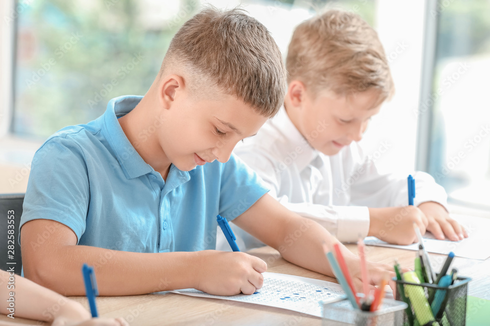 Pupils passing school test in classroom Pupils passing school test in classroom