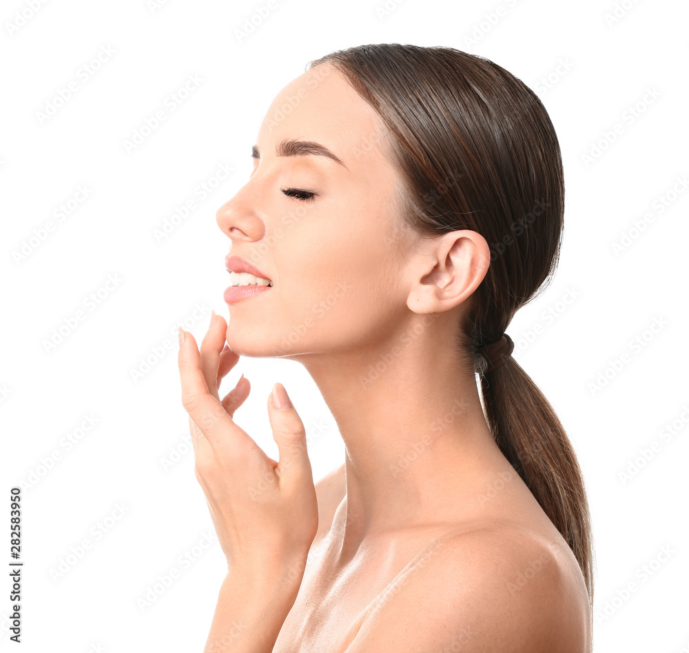 Beautiful woman massaging her face against white background