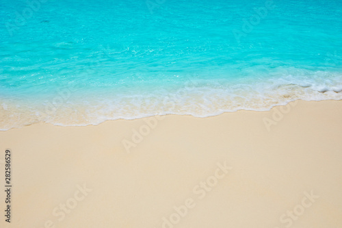 Soft waves of blue sea on the Maldives beach for the background.