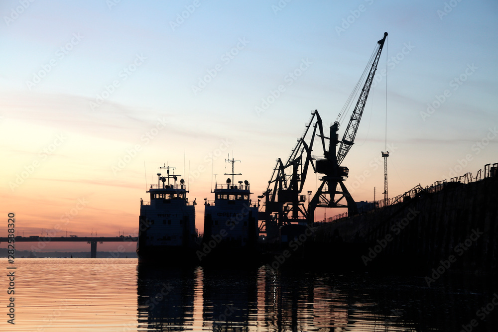 silhouettes of ships on a river