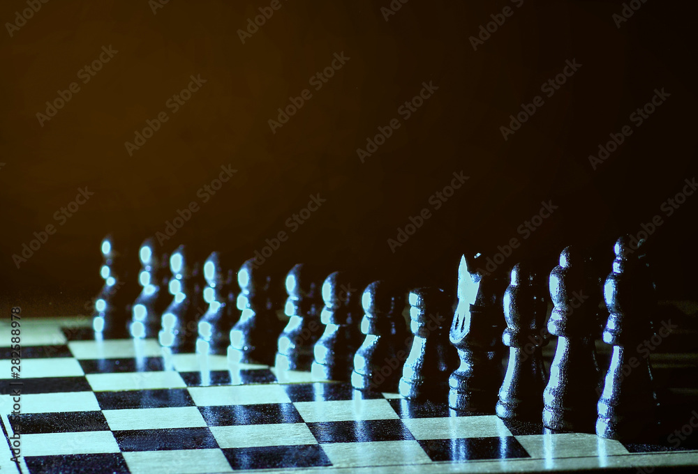 Composition with chessmen on glossy chessboard. photo on a dark background