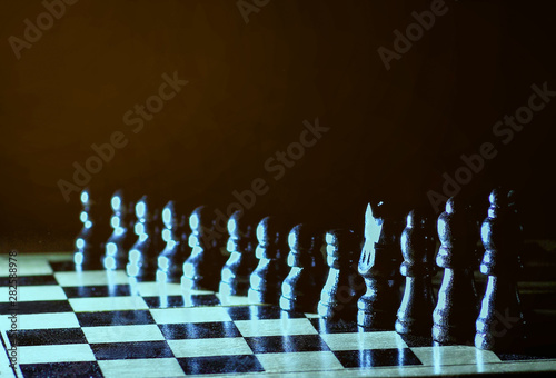 Composition with chessmen on glossy chessboard. photo on a dark background