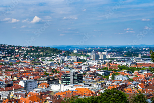 Germany, Wide view aerial above the red roofs of stuttgart city and feuersee church in basin surrounded by hills in summer
